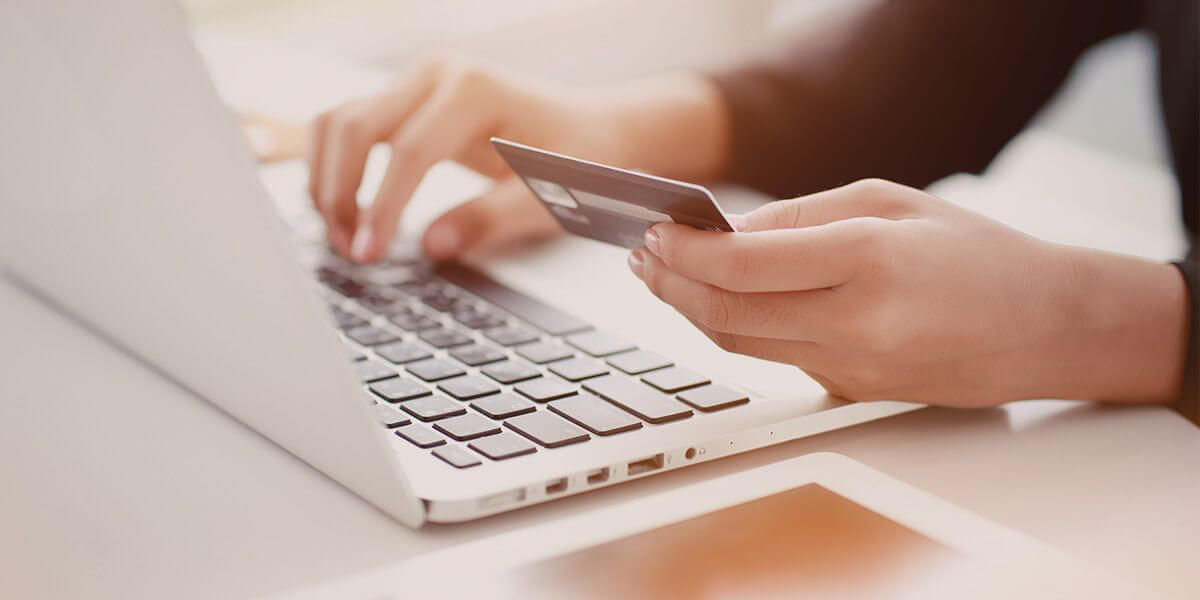 Einkaufen und Online-Bezahlung mit Notebook mit Sonnenlicht